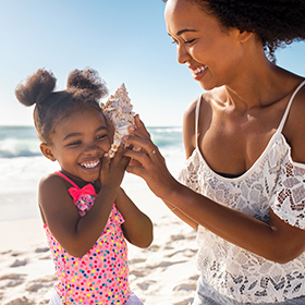 A mom and her daughter listening to a sea shell