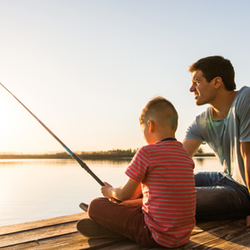 dad teaching his son how to fish